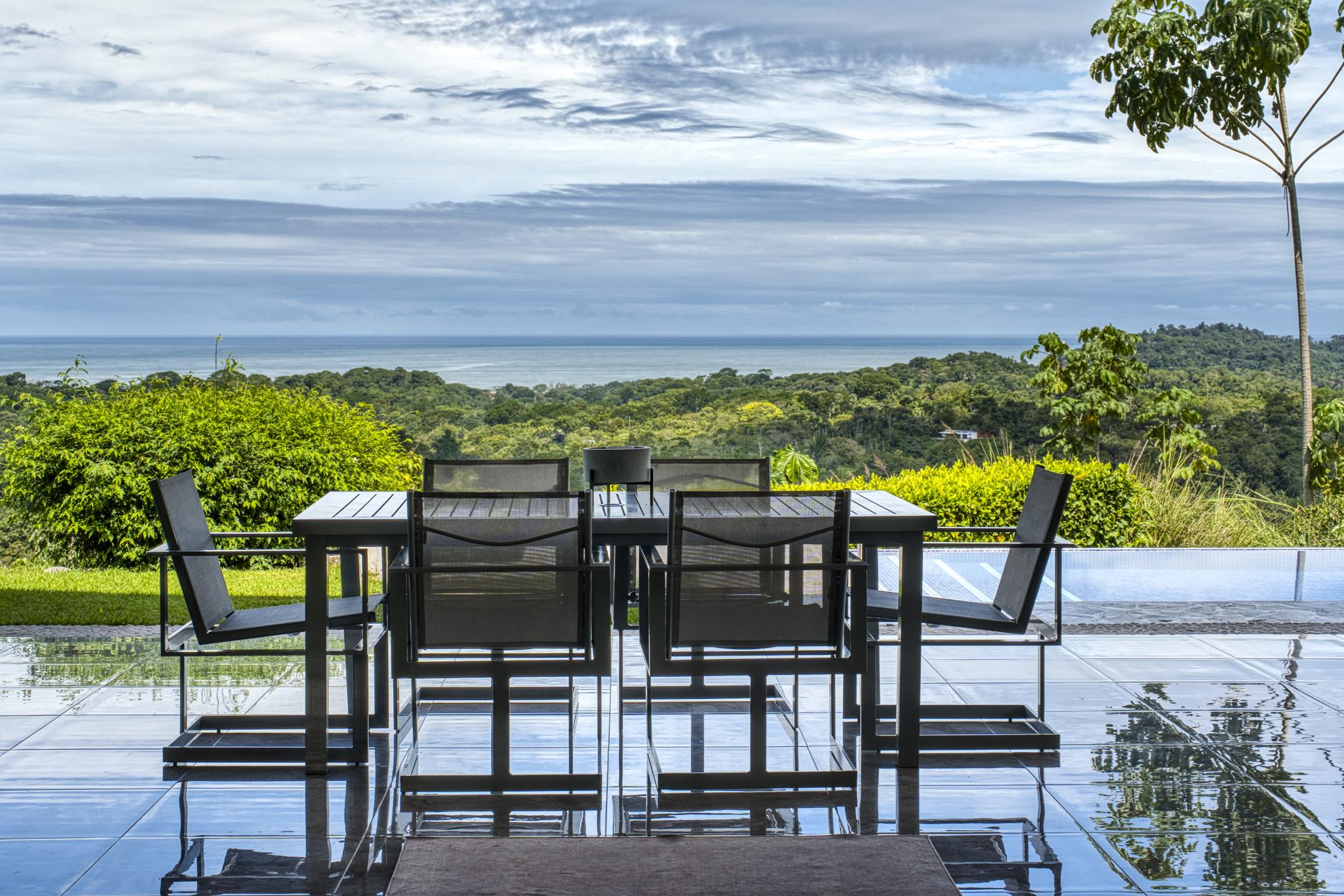 This outdoor dining space on a reflective tiled terrace provides direct views of the surrounding jungle and ocean.