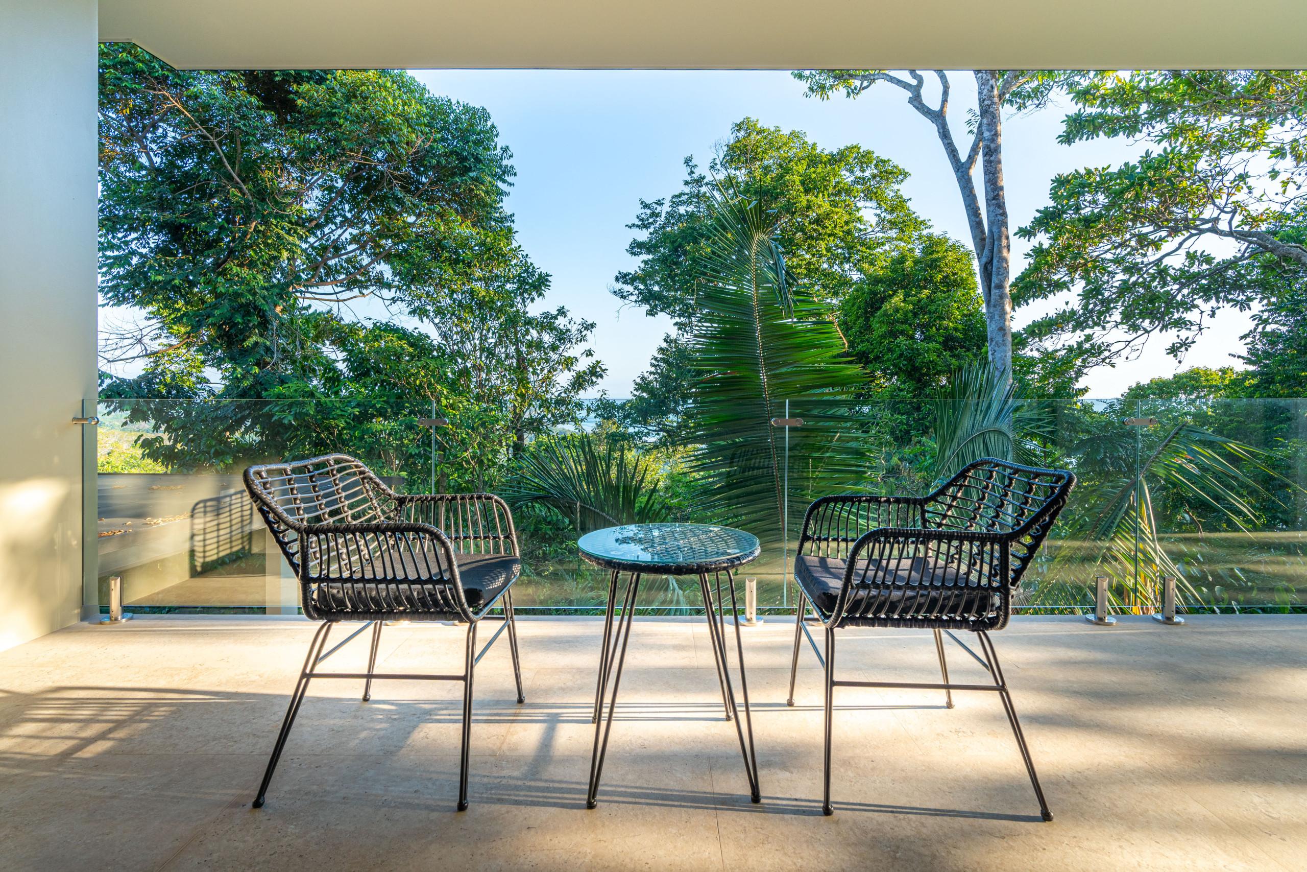 This private outdoor terrace provides contemporary seating for two with views across the lush tropical canopy to the distant ocean.