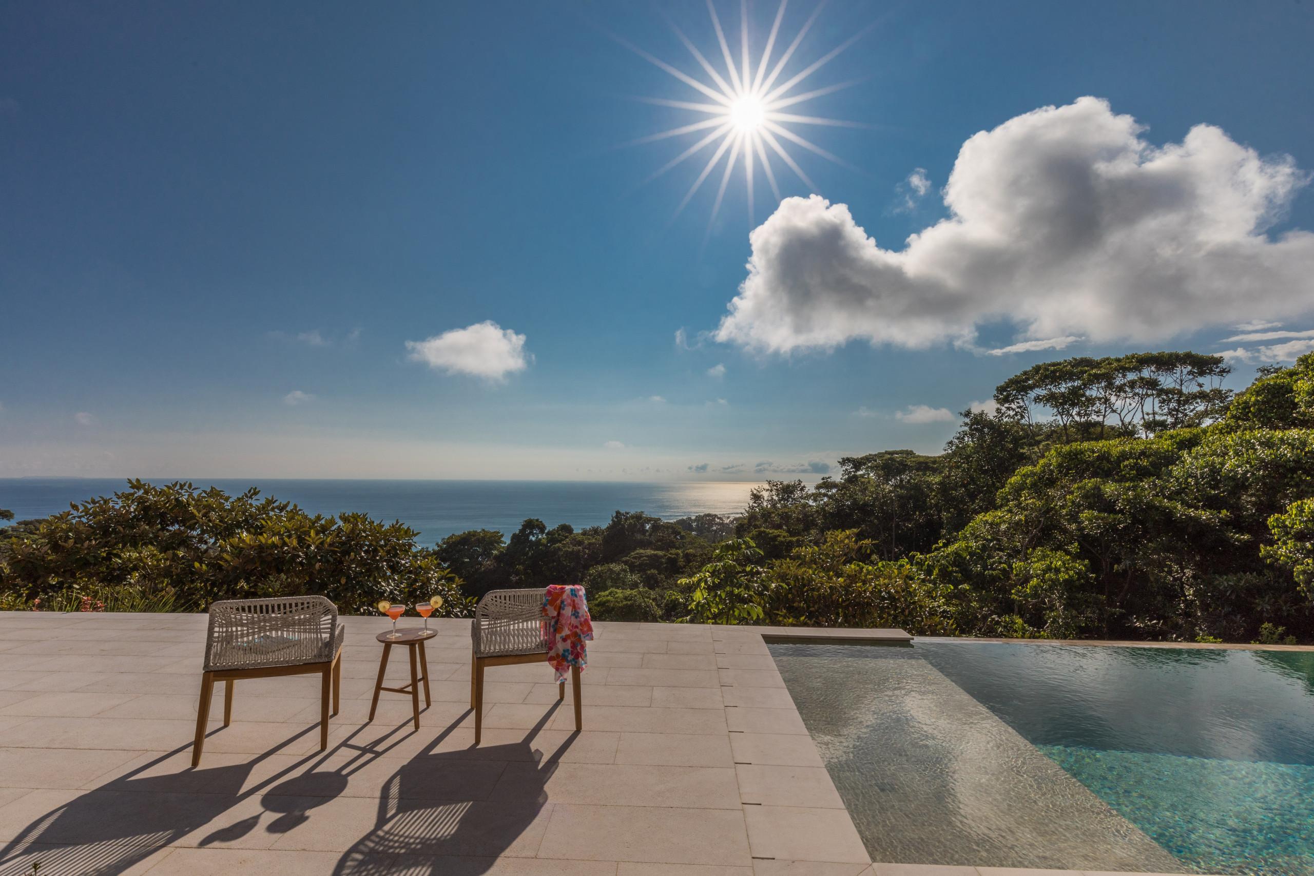 A saltwater infinity pool and sun-drenched deck offer expansive views of the Pacific Ocean and surrounding jungle.