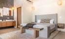 This spacious king-suite bedroom features an open-concept double vanity bathroom and contemporary design, offering a bright and comfortable private space.